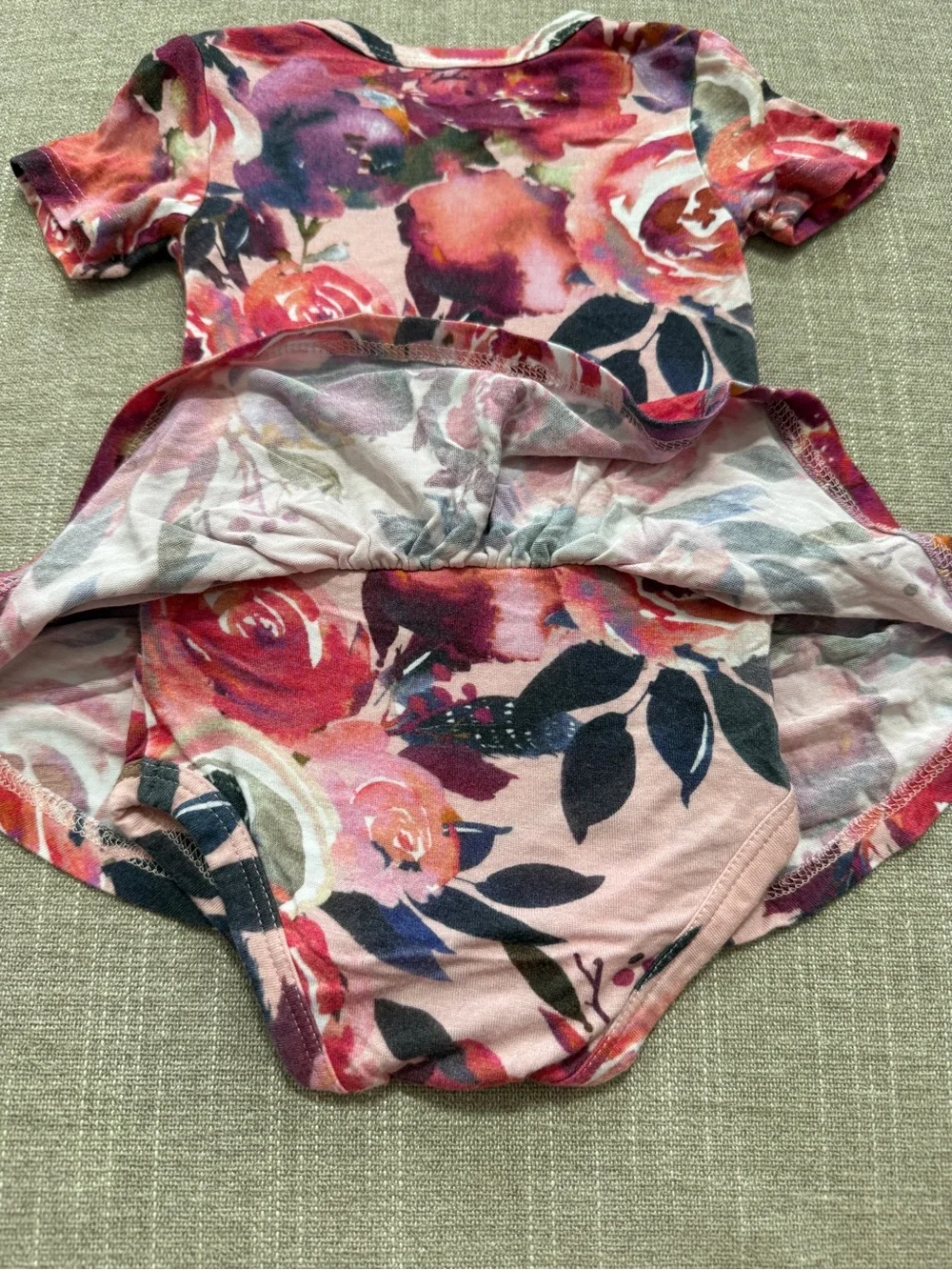 Posh Peanut twirl bodysuit features a Dusk Rose floral print 0-3M
